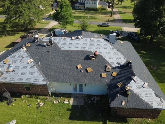 Aerial view of residential roof replacement with gray architectural shingles and protective underlayment